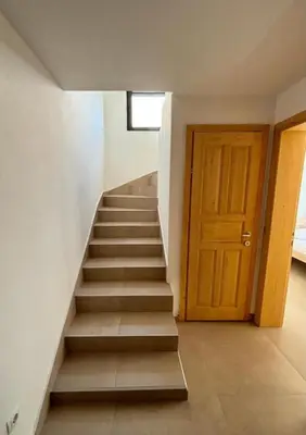 a staircase with a wooden door in a room at B&K Villa Kruče Rooms in Ulcinj