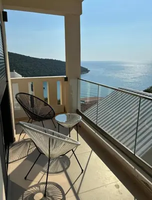 two chairs and a table on a balcony with the ocean at B&K Villa Kruče Rooms in Ulcinj