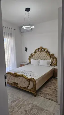 a bedroom with a large bed with a gold frame at Apartments Liards in Ulcinj