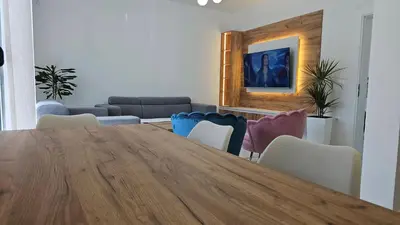 a living room with a wooden table and chairs at Apartments Liards in Ulcinj