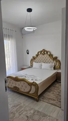 a bedroom with a large bed with a gold frame at Apartments Liards in Ulcinj