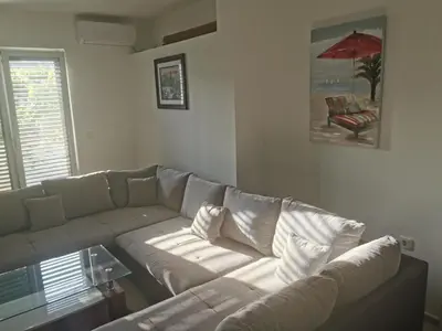 a living room with a white couch and a red umbrella at Laguna in Donji Štoj