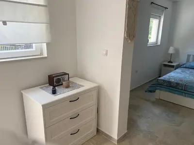 a bedroom with a dresser with a clock on it at Cozy Kotor apartment in Dobrota