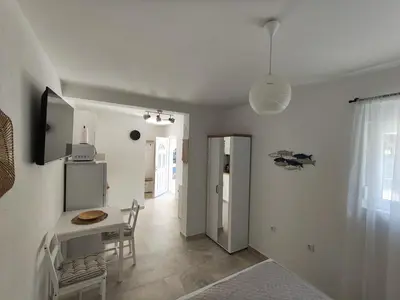 a kitchen and dining room with a table and a refrigerator at Cozy Kotor apartment in Dobrota