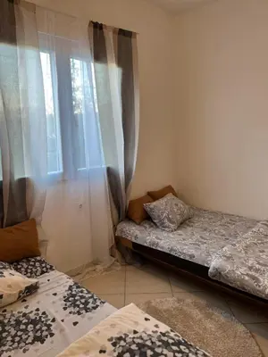 two beds sitting in a room with a window at Studio Apartmani Delić