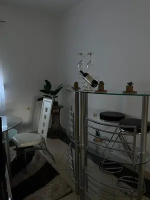 a room with a table and two chairs and a glass table at Studio Apartmani Delić