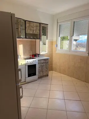 a kitchen with white appliances and a tile floor at Studio Apartmani Delić