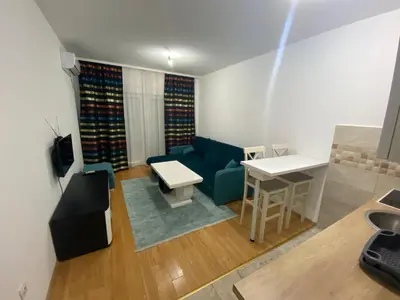 a living room with a blue couch and a table at Apartman Podgorica in Podgorica