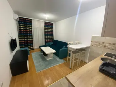 a living room with a blue couch and a table at Apartman Podgorica in Podgorica