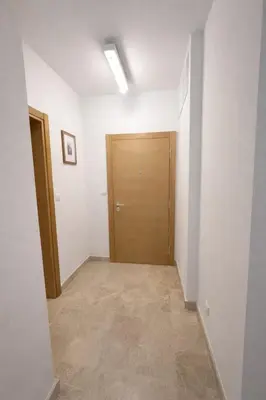 an empty hallway with a wooden door in a room at Libertina Rafailovici in Rafailovici