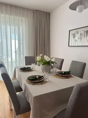 a dining room table with a vase of flowers on it at Libertina Rafailovici in Rafailovici