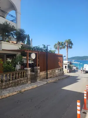 a street with a fence on the side of a building at Libertina Rafailovici in Rafailovici