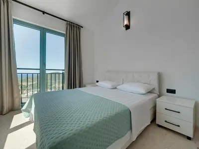 a bedroom with a bed and a balcony at Villa Zvis Sea View with Private Pool & Peaceful Stay in Budva