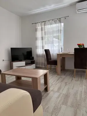 a living room with a table and a television at Apartment Matija in Cetinje