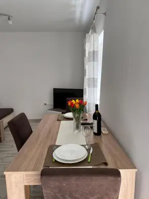 a wooden table with a plate and flowers on it at Apartment Matija in Cetinje