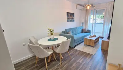 a living room with a table and chairs and a couch at kotor apartman 3 in Kravlja