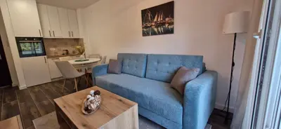 a living room with a blue couch and a table at kotor apartman 3 in Kravlja