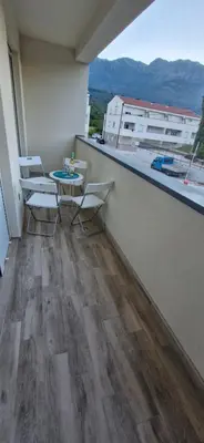 a balcony with a table and chairs on a building at kotor apartman 3 in Kravlja