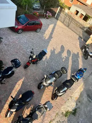 a group of motorcycles parked in a parking lot at Asijaapartmani in Bar