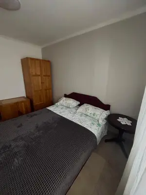 a small bedroom with a bed and a table at Seaside Ilino in Bar
