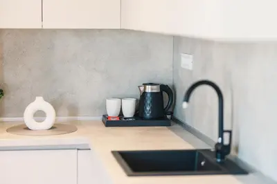a kitchen counter with two cups and a sink at Dani Deluxe Apartments in Ulcinj