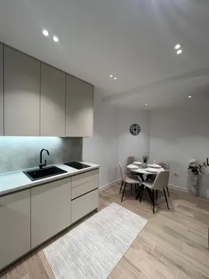 a kitchen with a sink and a table with chairs at Dani Deluxe Apartments in Ulcinj