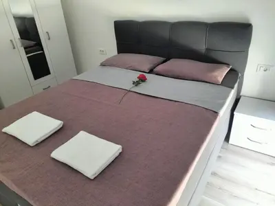 a bed with two pillows and a rose on it at Montenegro Ulcinj Apartments in Kravlja