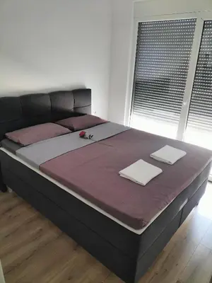 a large bed with two napkins on top of it at Montenegro Ulcinj Apartments in Kravlja