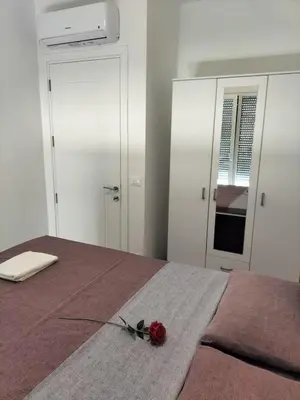 a red rose on a bed in a bedroom at Montenegro Ulcinj Apartments in Kravlja