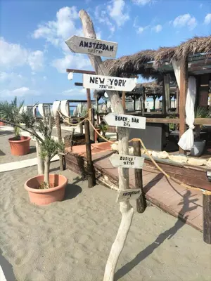 a sign with directions to different places on the beach at Montenegro Ulcinj Apartments in Kravlja