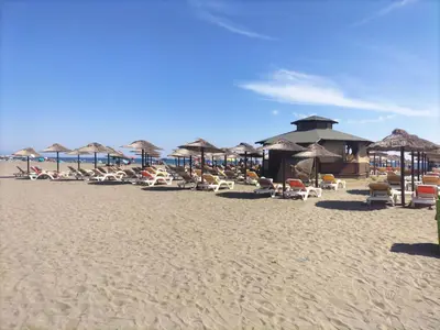 a beach with chairs and umbrellas on the sand at Montenegro Ulcinj Apartments in Kravlja