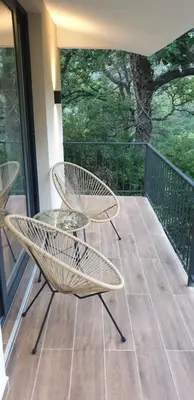 a patio with two chairs and a table on a balcony at Forest Nest Bartula in Bar