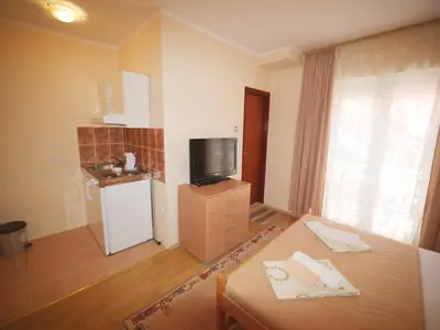 a room with a table and a tv and a kitchen at Lidia Apartments in Budva