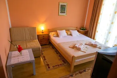 a small bedroom with a bed and a chair at Lidia Apartments in Budva