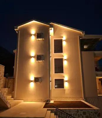 a white building with lights on the side of it at ZEN Studio Apartman in Kotor