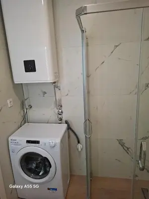 a washing machine in a bathroom with a shower at ZEN Studio Apartman in Kotor