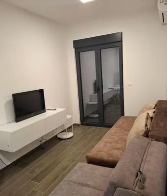 a living room with a tv and a couch at ZEN Studio Apartman in Kotor