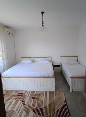 a bedroom with two beds and a rug at Jasmin 3 in Ulcinj