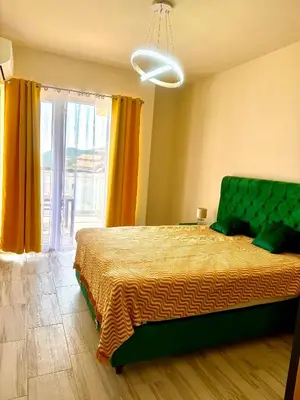 a bedroom with a bed and a large window at Sunny Hills Apartment in Seoca