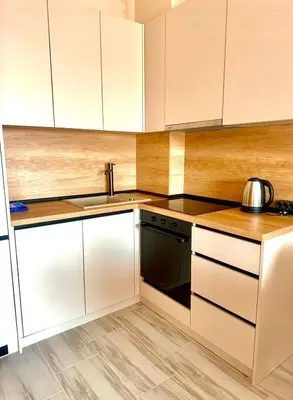 a kitchen with white cabinets and a black dishwasher at Sunny Hills Apartment in Seoca