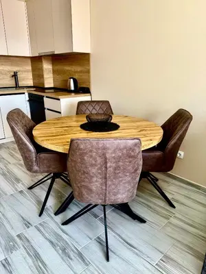 a kitchen with a wooden table and chairs at Sunny Hills Apartment in Seoca