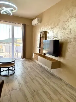 a living room with a flat screen tv on the wall at Sunny Hills Apartment in Seoca