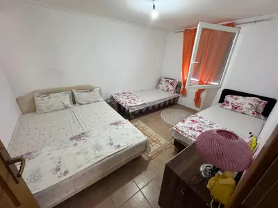 a room with two beds and a table and a window at Apartman Adea in Donji Štoj