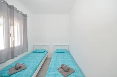 two beds in a white room with towels on them at Holiday Home Stanka in Kotor