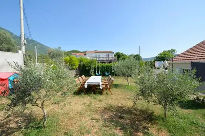 a table and chairs in a yard with trees at Holiday Home Stanka in Kotor