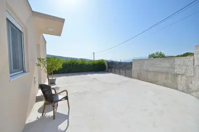 a chair sitting on the balcony of a house at Holiday Home Stanka in Kotor