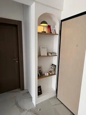 a hallway with a door and a shelf with books at Stylish Coastal Apartment in Kotor