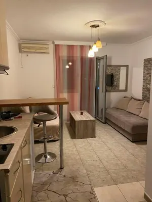 a kitchen and living room with a table and a couch at Budva in Budva