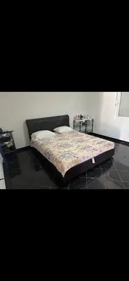 a bed in a room with a black floor at Agron apartments in Ulcinj