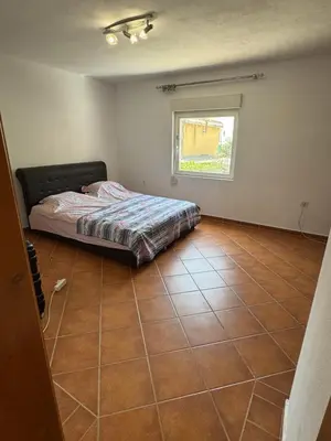 a bedroom with a bed sitting on a tiled floor at Agron apartments in Ulcinj